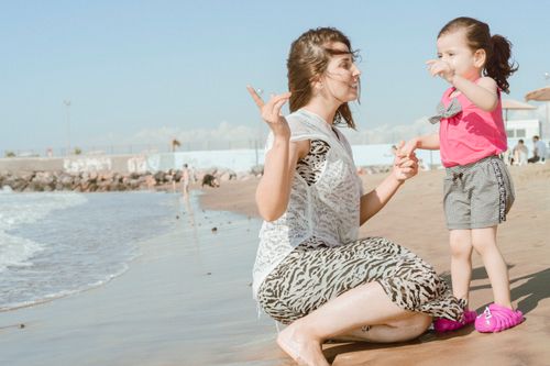 Free A mother and her daughter playing joyfully on a sunny İskenderun beach, showcasing bonding and happiness. Stock Photo