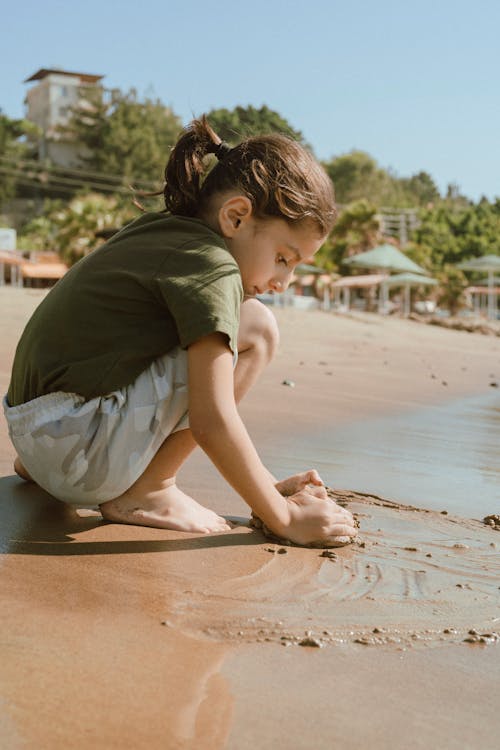 A Kid Playing Sand at the Beach