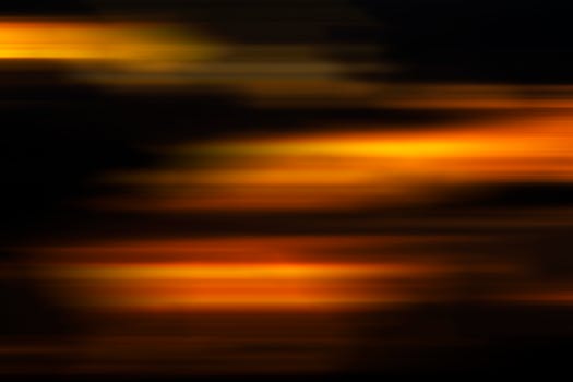 A vibrant abstract background with a dynamic orange and yellow gradient, evoking motion and warmth.