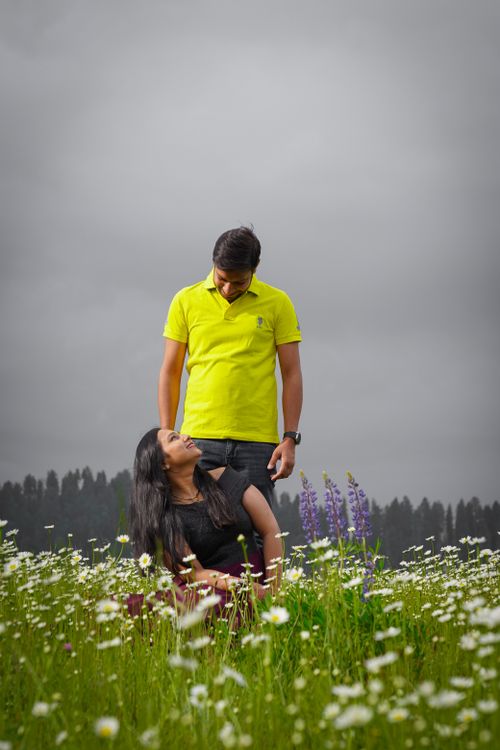Free A romantic couple enjoying a moment in a lush flower field in Gulmarg. Stock Photo