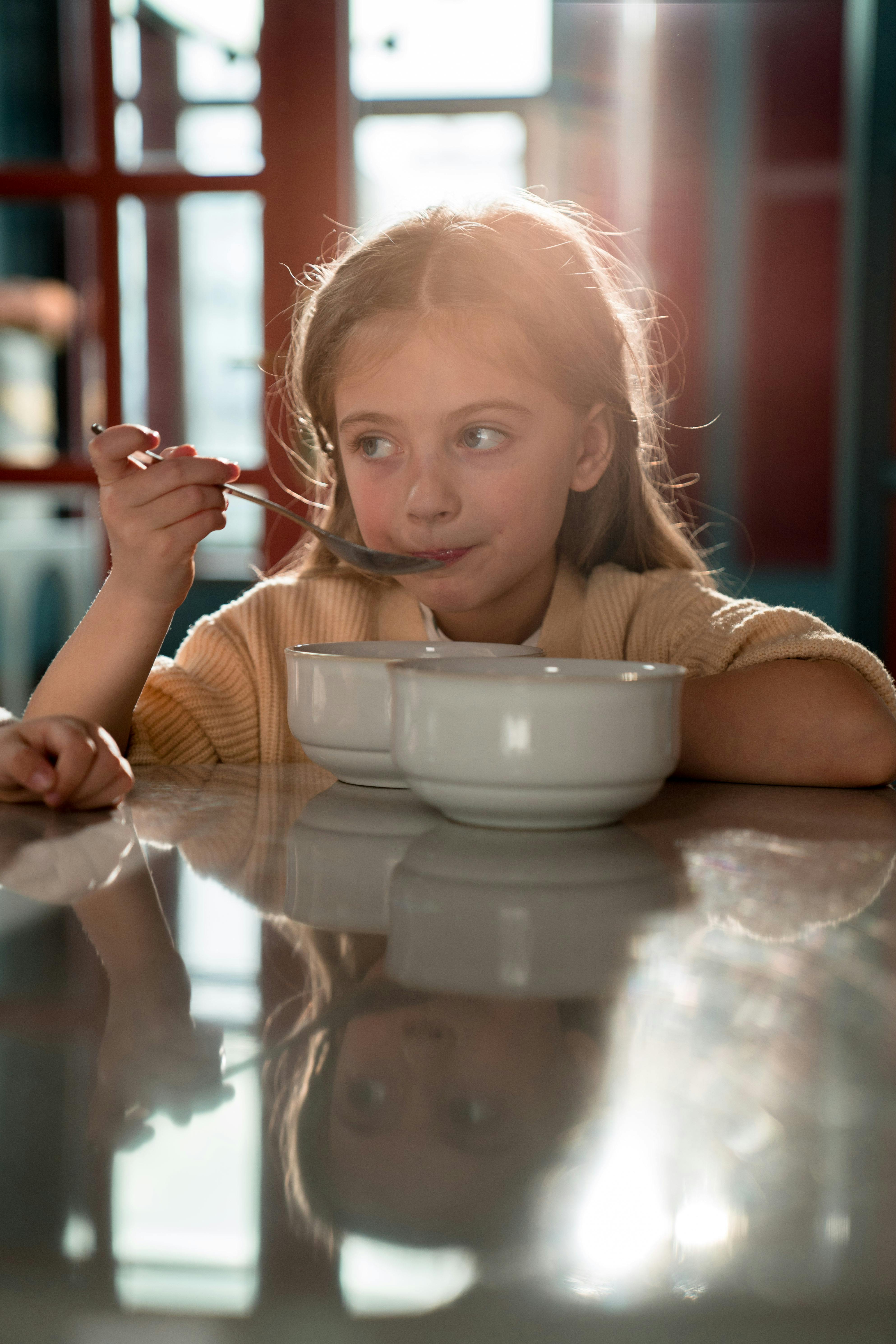 Girl in Yellow Sweater Holding Silver Spoon · Free Stock Photo