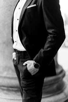 Monochrome image showcasing a man in a black suit, embodying elegance and style.