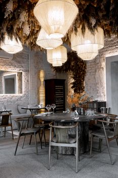Elegant rustic dining setup with woven lamps and wooden decor in a cozy restaurant.