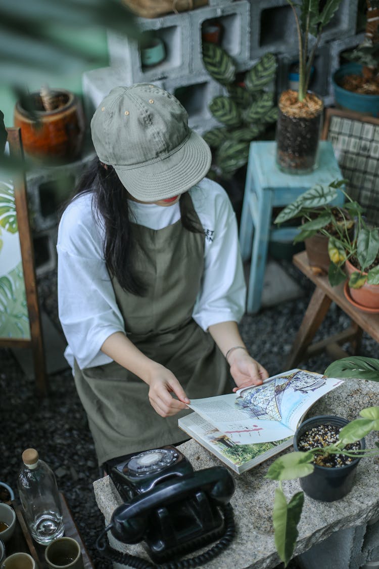 Woman In White Shirt And Gray Hat Reading A Book