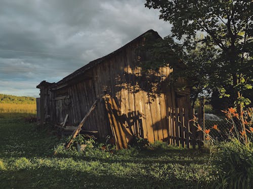 A Wooden Barn on a Grassy Field