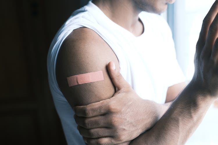 Man In White Tank Top With Band Aid On Arm