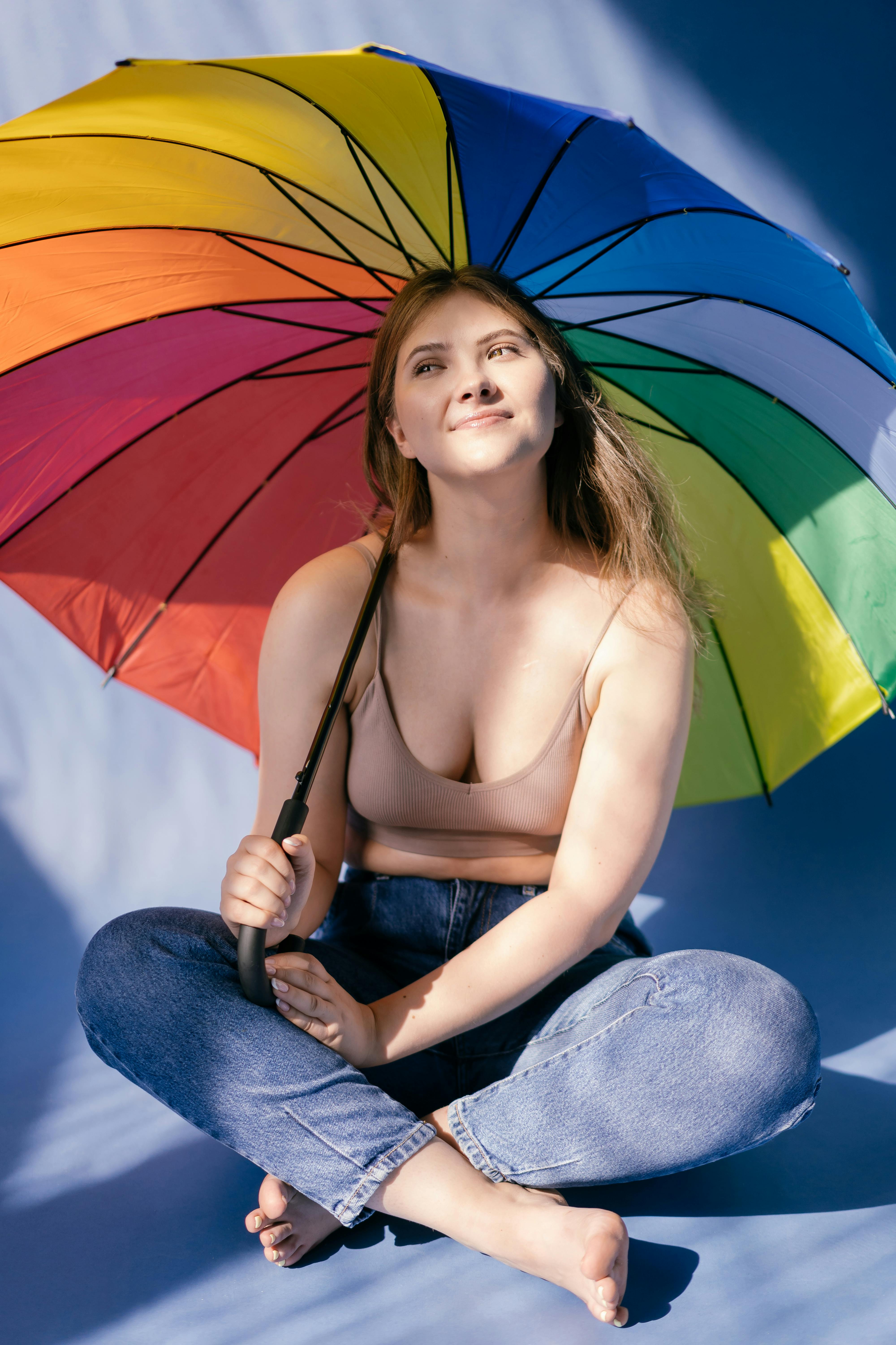 a woman in beige halter top holding an umbrella