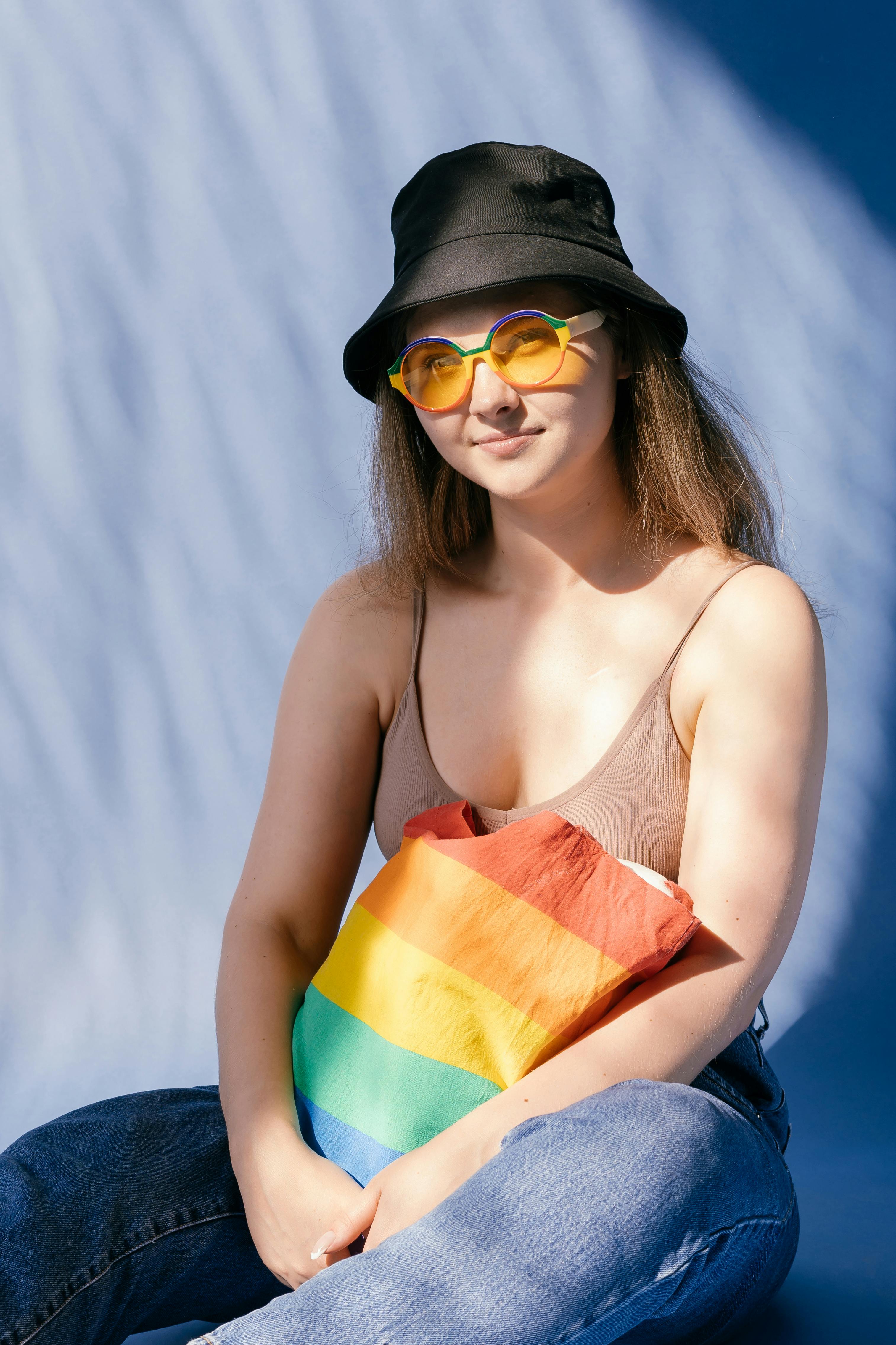 a woman in beige halter top holding a rainbow tote bag