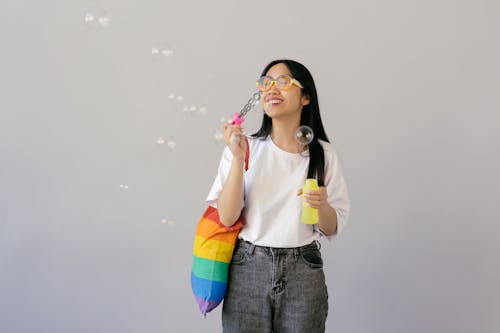 Woman in White Shirt Blowing Bubbles