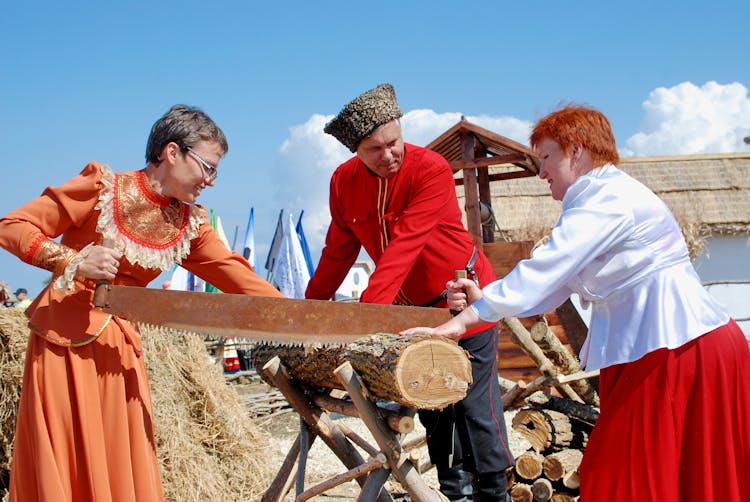 People Sawing A Wood Log