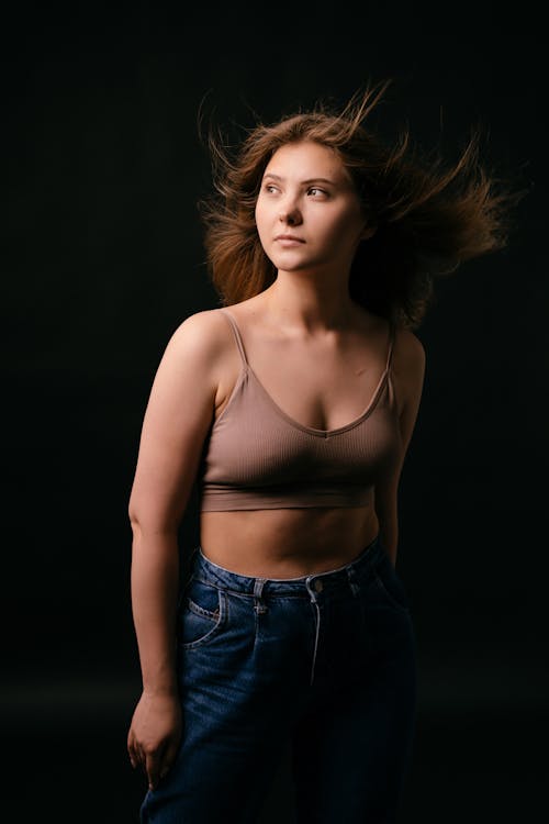 Woman in Crop Top Sleeveless Top and Denim Jeans