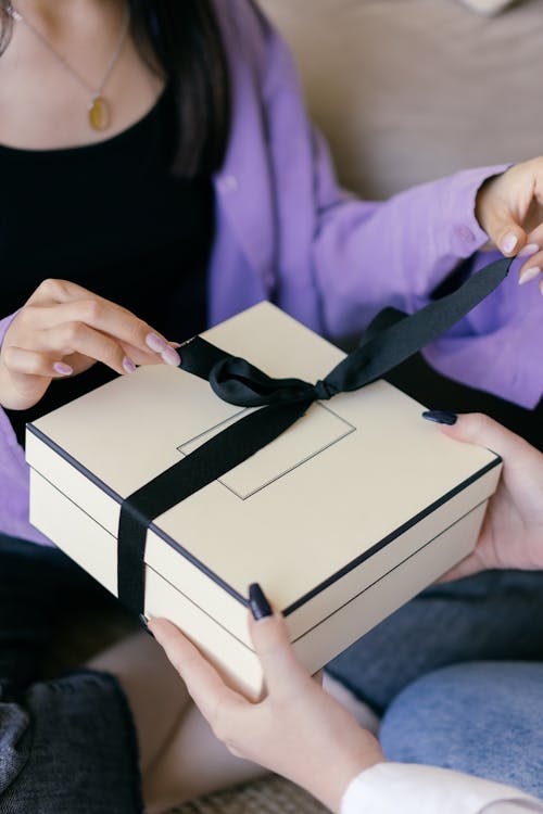 Free Woman Putting a Ribbon on a Gift Box Stock Photo
