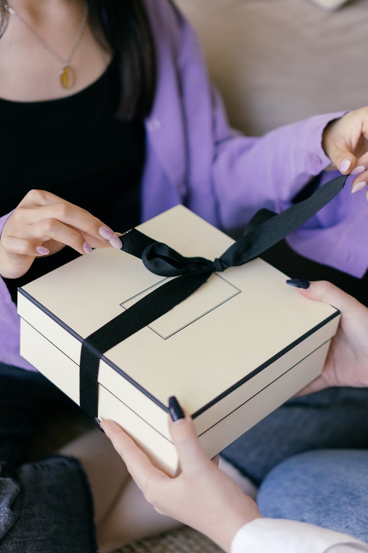 Woman Putting A Ribbon On A Gift Box