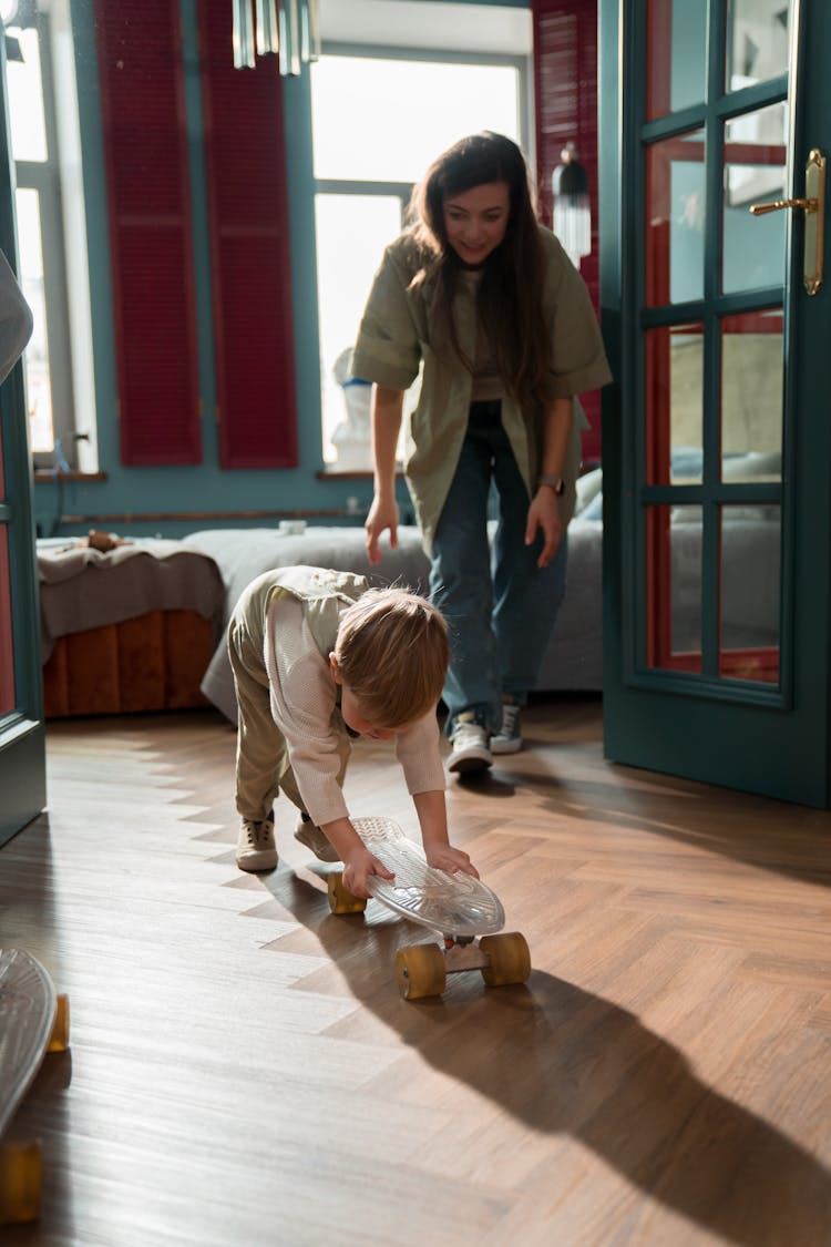 Mother And Son Playing A Skateboard