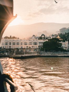 A picturesque view of an urban waterfront at sunset, with elegant buildings reflecting in the river.