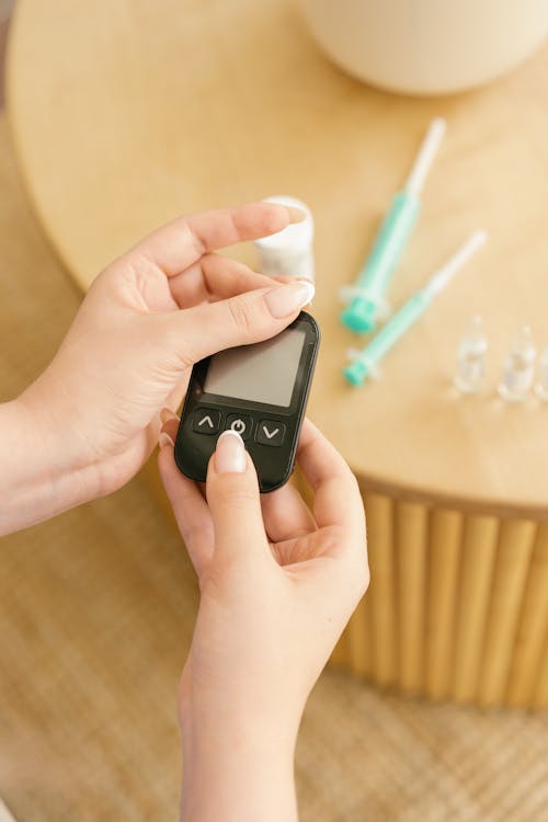 Close-Up Shot of a Person Holding a Black Glucometer