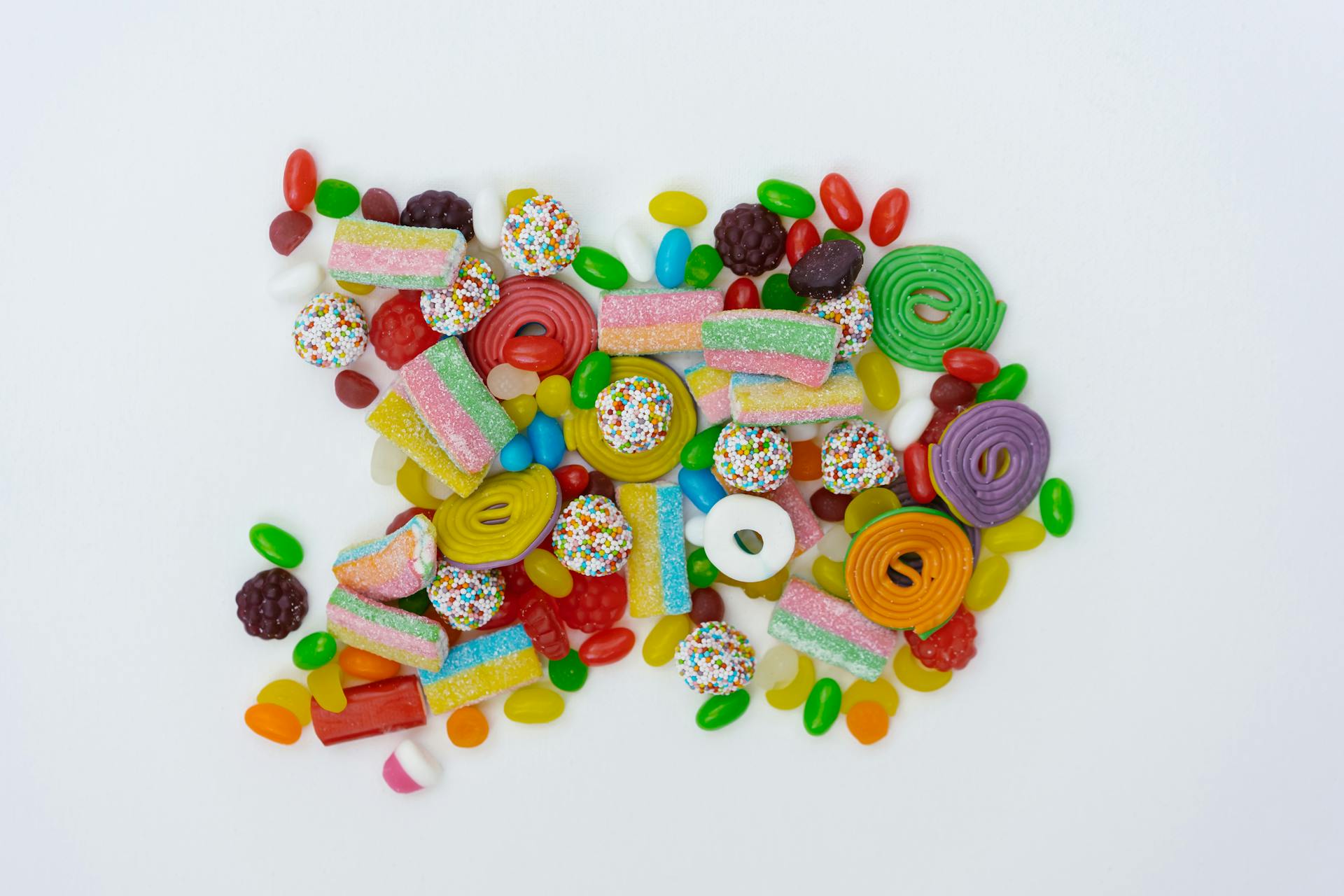 Close-Up Shot of Assorted Candies on a White Surface