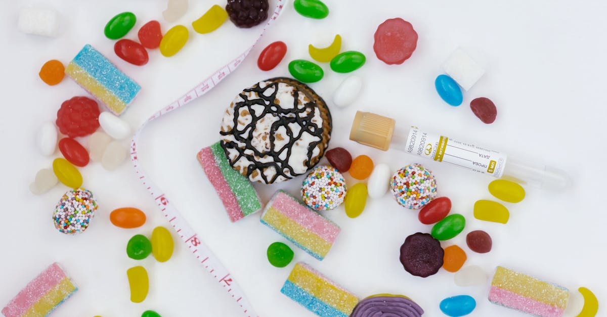 Top view of assorted candies, cookies, and a tape measure symbolizing unhealthy diet choices.