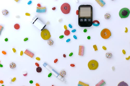 Glucose Meter Lying among Scattered Candies