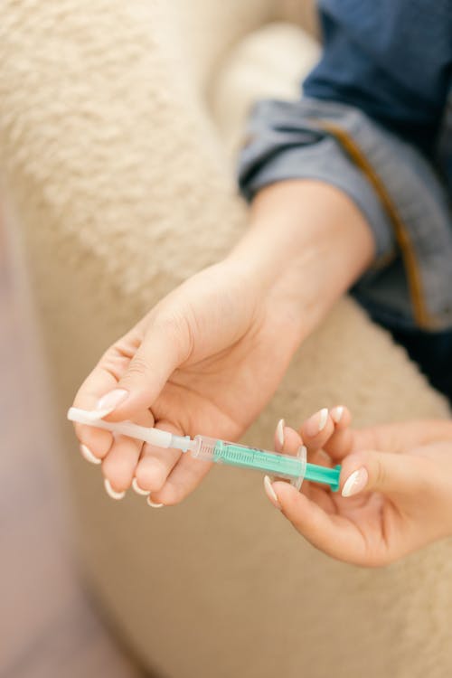 Close-Up Shot of a Person Holding a Syringe