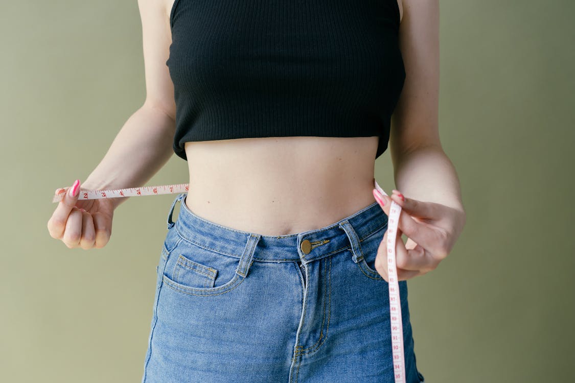 Free 
A Woman in a Crop Top Measuring Her Waist Stock Photo