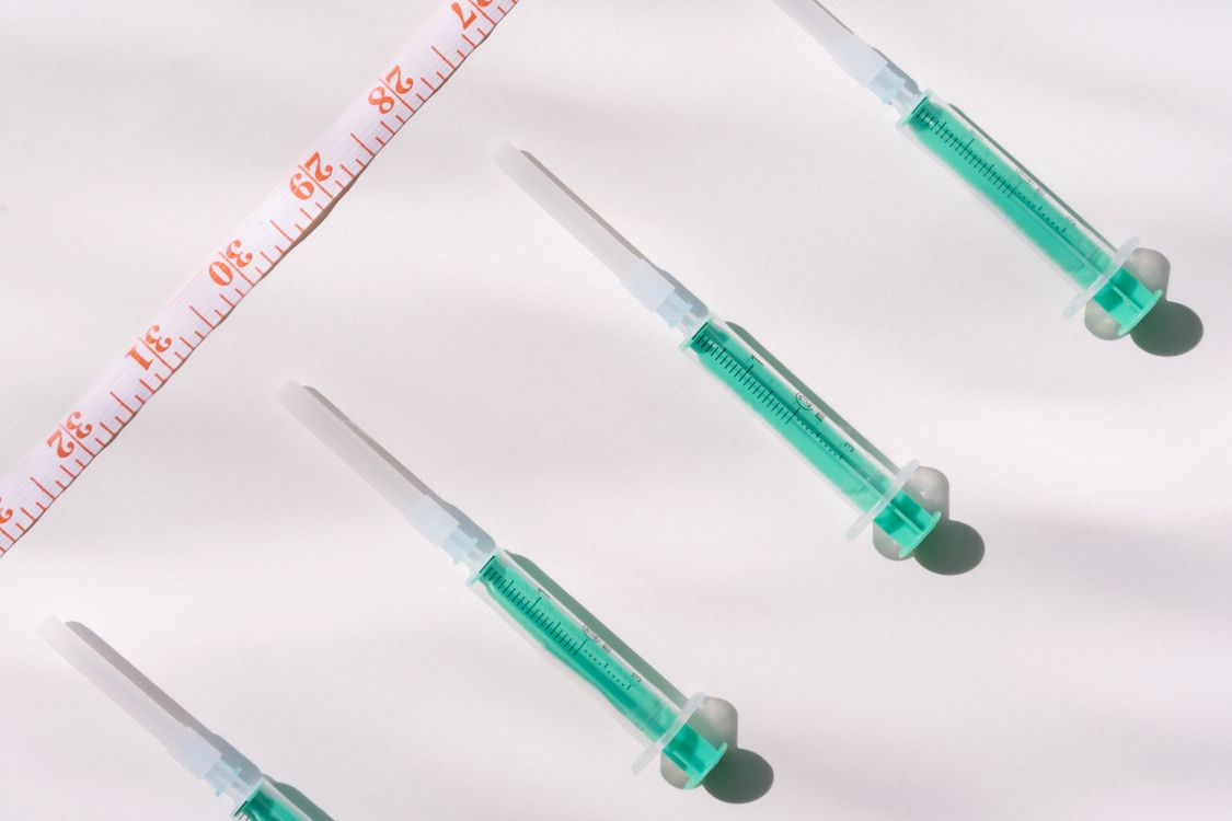 Medical injection pens on a desk representing GLP-1 drug treatment options
