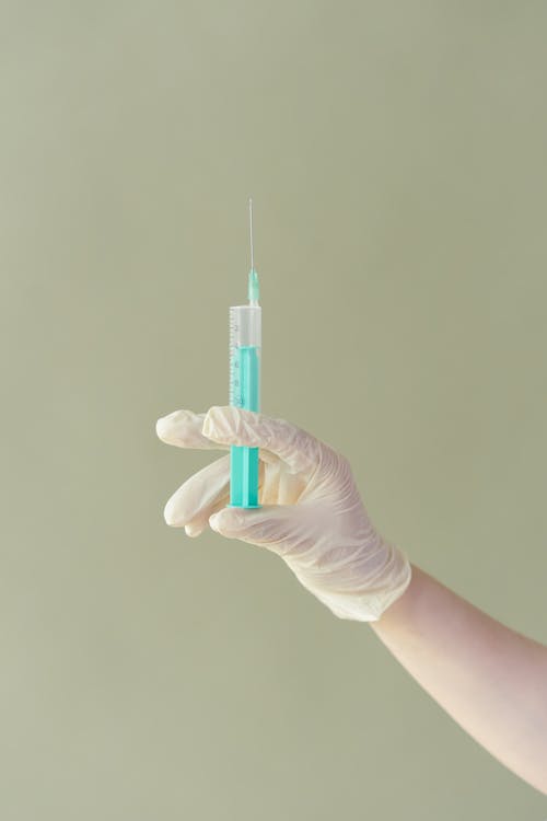 Hand with Glove Holding a Syringe