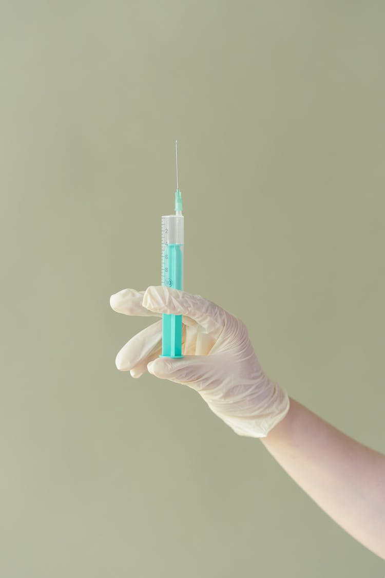 Hand With Glove Holding A Syringe