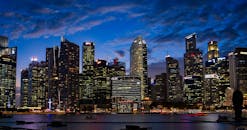 新加坡天际线展现出壮丽景色，明亮的摩天大楼在黄昏的天空下显得格外耀眼