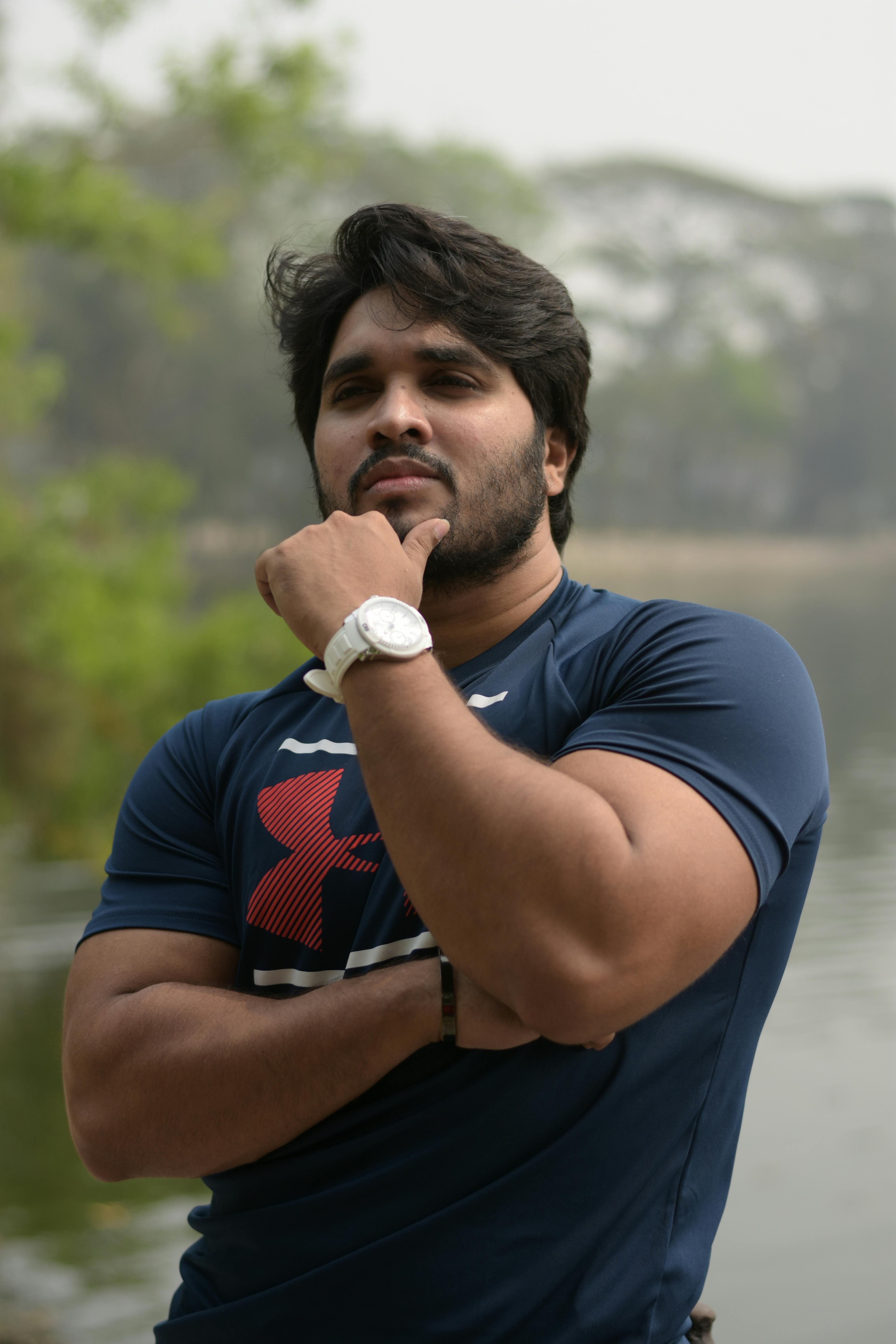 Portrait of a confident man posing thoughtfully by a scenic lakeside in Kolkata, India.