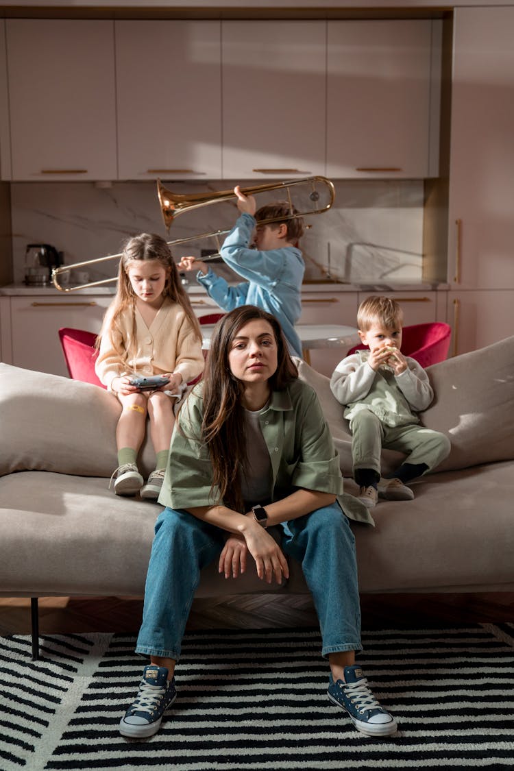 A Woman And Children Sitting On The Sofa