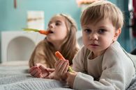 Girl in White Sweater Holding Orange Carrot