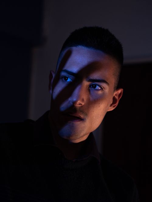 Free Dramatic portrait of a man in shadows with a serious expression, captured in low light setting. Stock Photo