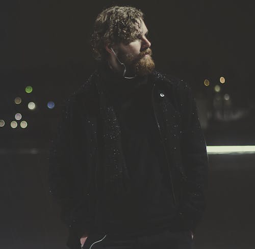 Man Wearing Black Zip-up Jacket Taking Picture during Nighttime