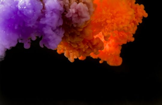 A mesmerizing display of vibrant purple and orange ink creating abstract patterns in water.