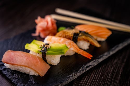 Variety of Sushi on Black Ceramic Plate