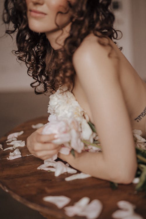 Topless Woman Covering her Breast with Flowers