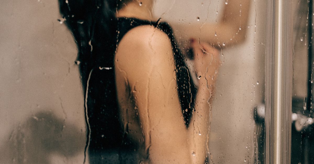 Rüyada Duygusal Arınma Yaşamak - Rüya Tabiri ve Anlamı - Moody portrait of a woman standing behind a wet glass door with water droplets.