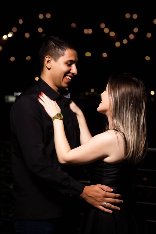 Free A romantic couple embraces at night with glowing lights in the background, evoking love and affection. Stock Photo