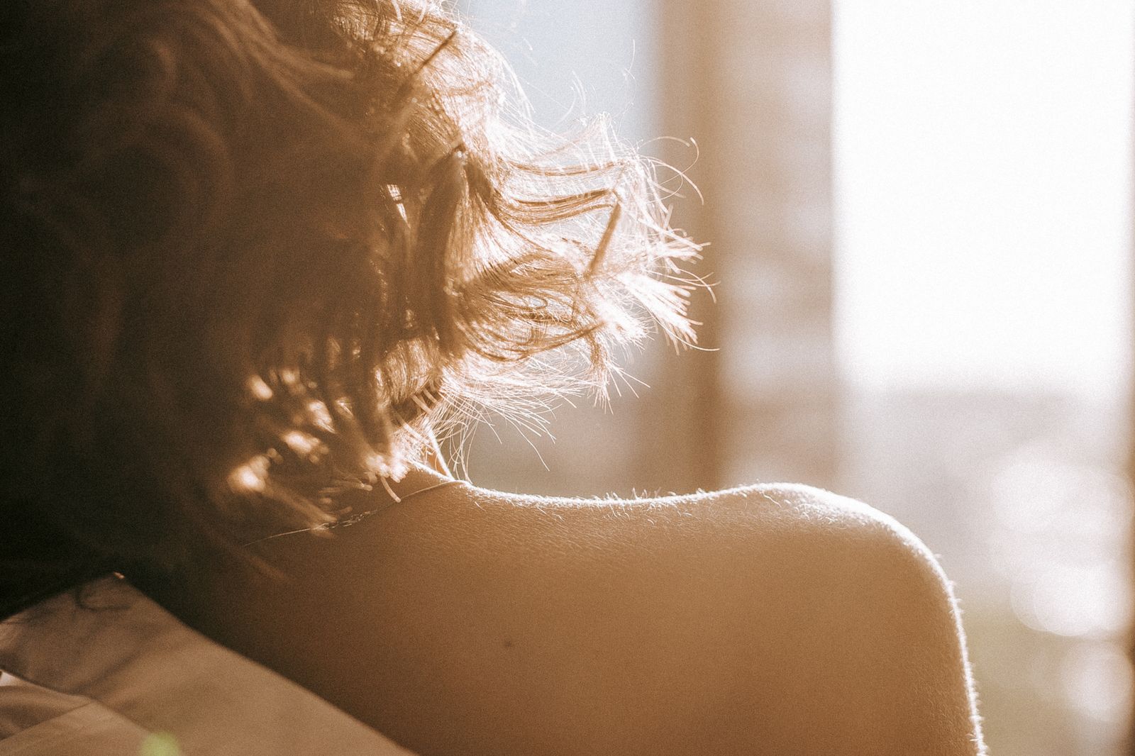 Shoulder and loose hair lit by low sunrise light — photo by Marina Ryazantseva on Pexels