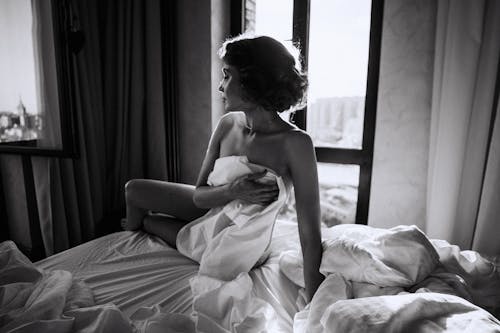 Free Monochrome Photo of a Woman Covering her Body with the Bed Sheet Stock Photo