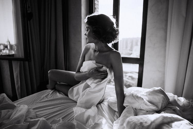 Monochrome Photo Of A Woman Covering Her Body With The Bed Sheet