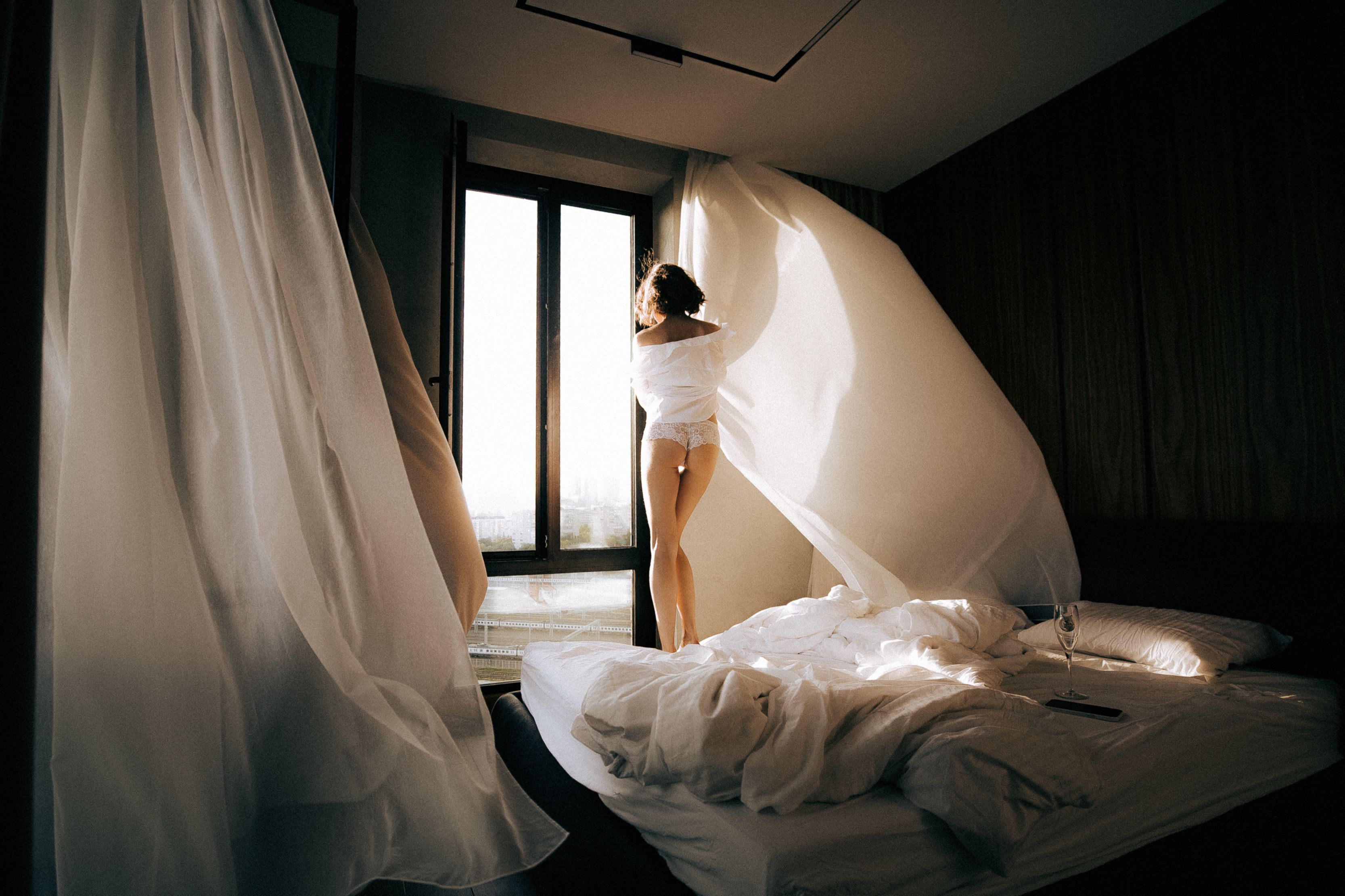 Elegant bedroom with flowing curtains and soft morning light