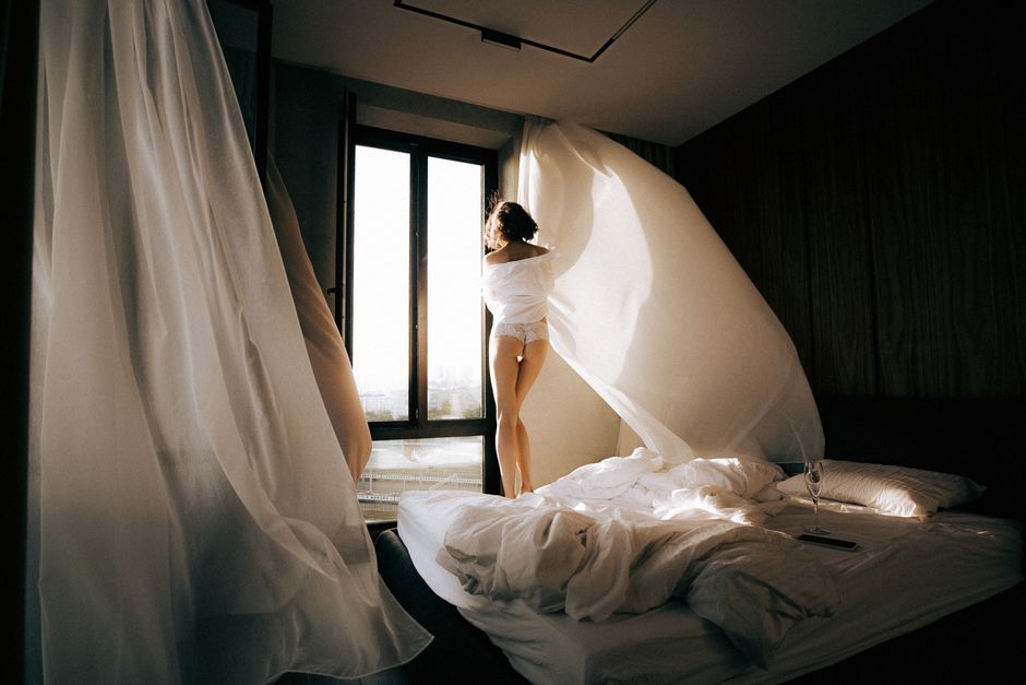 Elegant bedroom with flowing curtains and soft morning light