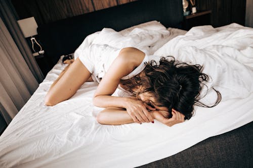 Free Woman in White Clothes Sleeping on a Bed Stock Photo