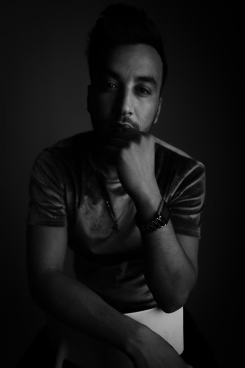 Free Moody black and white portrait of a man posing pensively in shadow. Stock Photo