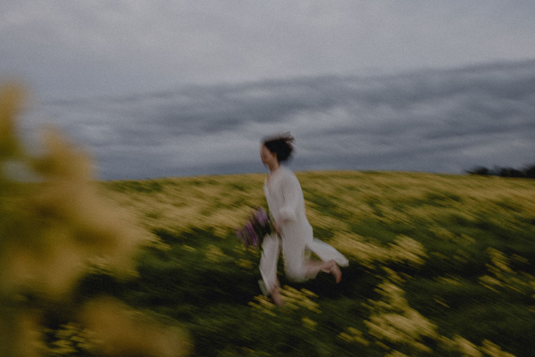 A motion-blurred figure running through a field of wildflowers at dusk — photo by Diana Smykova on Pexels