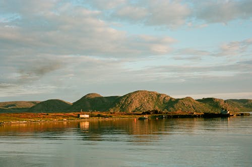 Brown and Green Mountains Beside Body of Water 