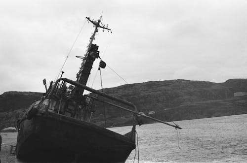 Grayscale Photo of Boat on the Shore