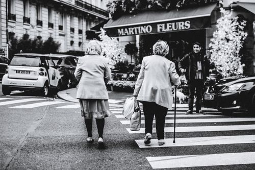 Free Black and white photo of elderly women crossing a zebra crossing in an urban setting. Stock Photo
